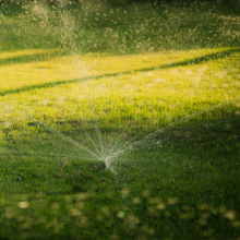 A picture of a garden sprinkler spraying water over a lawn